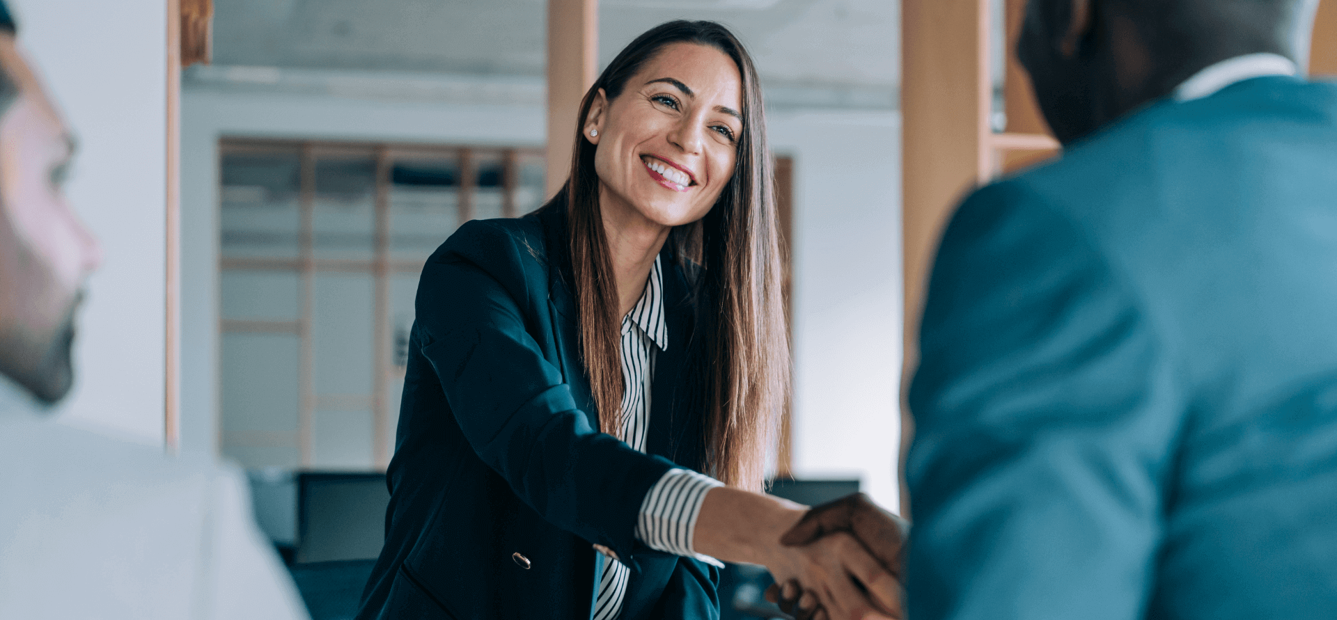 Gente dándose la mano en una oficina.